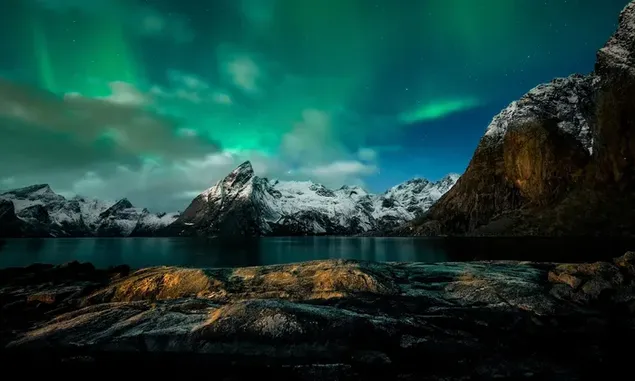 Spectacular northern lights accompanying the wonderful view of snowy mountains and lake water