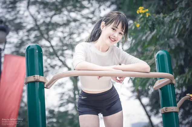 Chica asiática deportiva jugando en el parque con una sonrisa radiante descargar