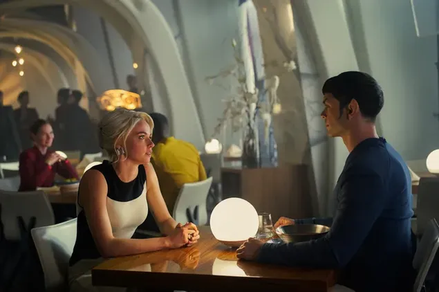 Телевизијска серија Звездане стазе прелепа плава жена и мушкарац седе за столом међу гомилом људи 2K позадина