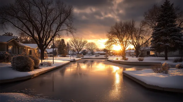 voorstedelike wintersonsondergang wat op 'n bevrore waterweg weerspieel aflaai