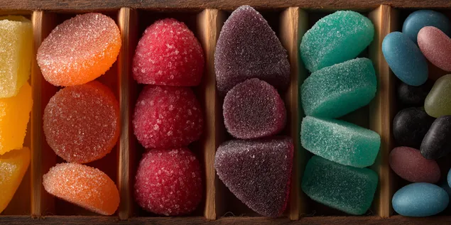 Suikergecoate vruchtengelei gerangschikt in houten compartimenten 2K achtergrond