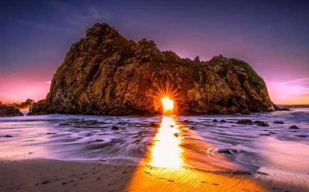 海の岩の島から差し込む日光