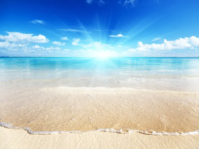 La luz del sol golpea la playa y el agua clara del mar a través de las nubes en el cielo azul 2K fondo de pantalla