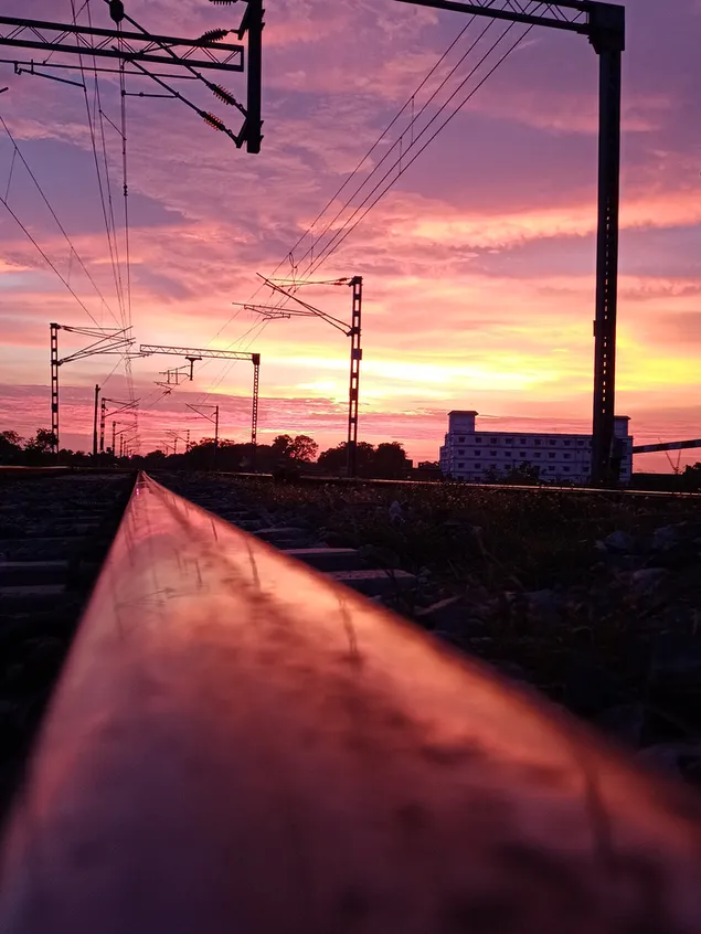 Zonsondergangspoorweg en verbazende roze bewolkte hemel download
