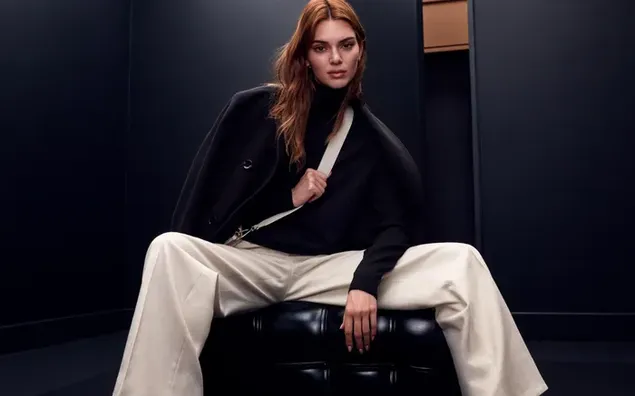 Supermodel und Prominente Kendall Jenner trägt ein schwarzes Langarmshirt, gepaart mit einer weißen Hose 4K Hintergrundbild