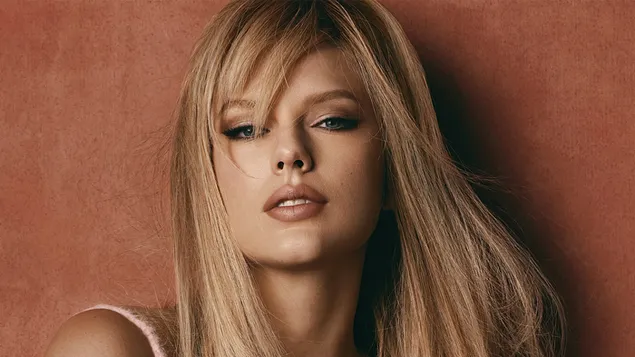 Taylor Swift blond włosy, niebieskie oczy, pomalowane usta i czerwone tło 4K tapeta