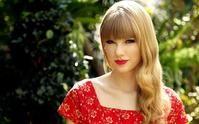 Taylor Swift tersenyum dalam gaun merah unduhan