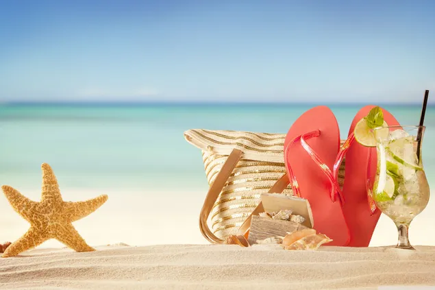 The best gift of the summer season is a cocktail, straw bag and a starfish on the sand.