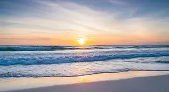 the gentle waves of the ocean glow with pastel hues as the sun rises, casting a peaceful light across the serene shoreline and reflecting in the calm download