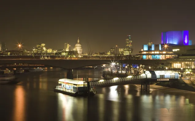 The glow of the buildings reflected in the water in the darkness of the city HD wallpaper