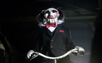 Die unverzichtbare Marionette der Saw-Film-Thriller-Szenen mit ihrem Fahrrad 2K Hintergrundbild