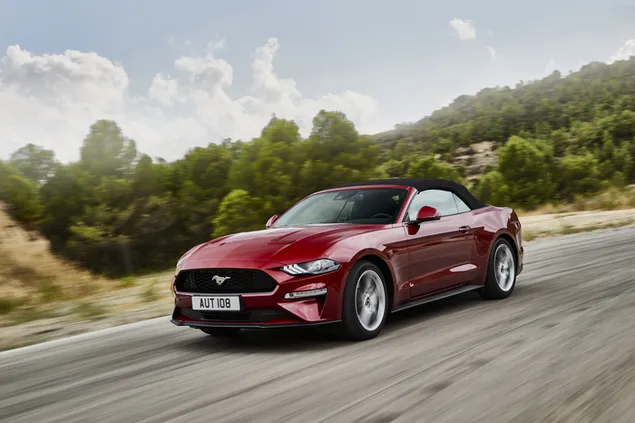 De legendarische rode cabrio Ford Mustang rijden op asfaltweg tussen wolken en bergen 4K achtergrond