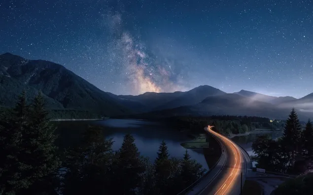 het melkwegstelsel zichtbaar aan de nachtelijke hemel boven een bergachtig download