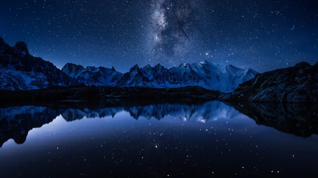 The silhouettes of snowy mountains reflected in the water