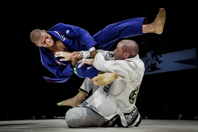 Perjuangan dua atlet berbaju biru dan putih melakukan Brazilian jiu jitsu unduhan