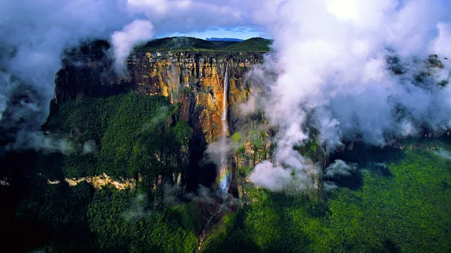 La vista de la cascada que fluye desde las colinas del bosque entre la niebla HD fondo de pantalla