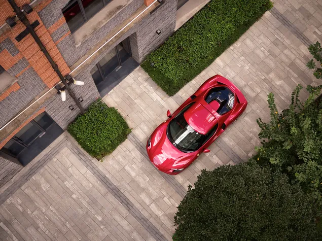 Top view of a red ferrari 296 gtb in front of a building