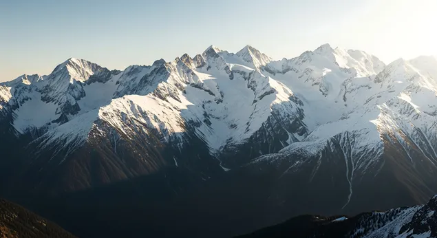 清晨的阳光洒在湛蓝的天空下，巍峨的雪山之巅巍峨耸立，光影交错，自然细节令人叹为观止。清晨的阳光捕捉了这壮丽的景色，画面中可见引人注目的阴影和令人惊叹的自然细节。 8K 壁纸