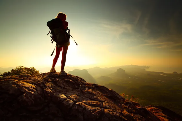 Reiziger vrouw met rugzak op kliffen en uitzicht op de natuur geschoten vanaf hoge heuvel HD achtergrond