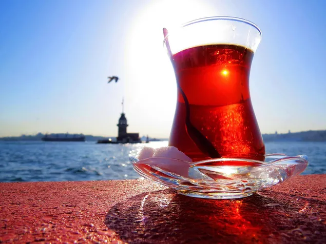 Turkish tea in a glass glass with sugar next to it, Istanbul Üsküdar Maiden's Tower with a sea view