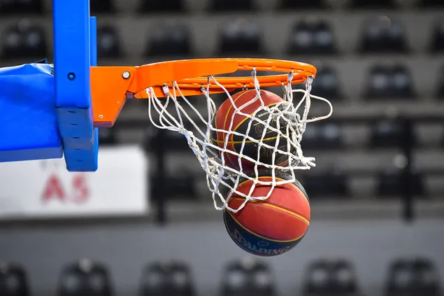 Two balls falling down through a basketball hoop