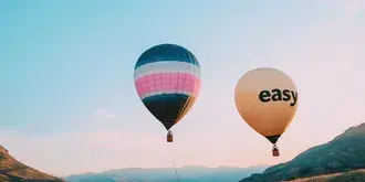 dva balona na vroc zrak lebdita ob soncnem zahodu nad gorskim prelazom prenos