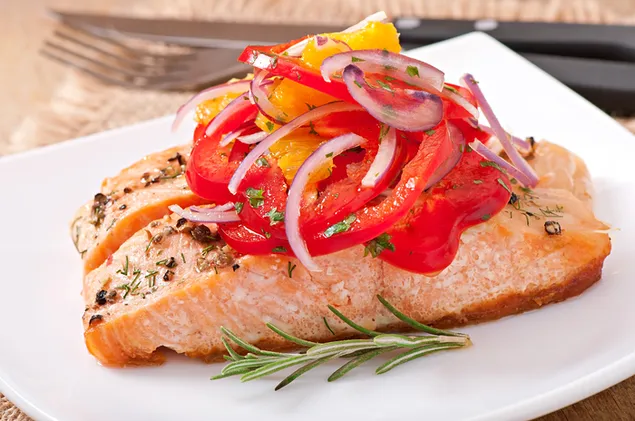 Taustpilt Kaks viilutatud lõhet paprika, sibula ja muude vürtsidega valgel taldrikul 4K