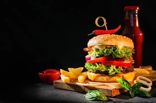 Überladener Burger mit Pommes und einer Flasche Ketchup