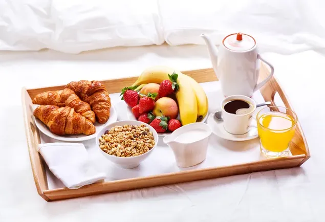 Una bandeja de desayuno típico occidental - Pan, frutas, cereales, café, leche y jugo