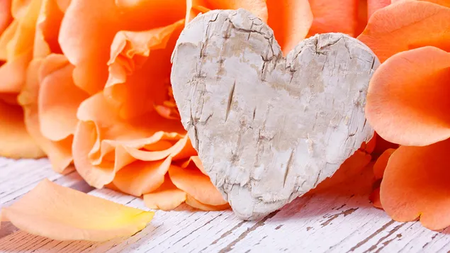 バレンタインデー-オレンジ色のバラの花びらを持つ木製の心