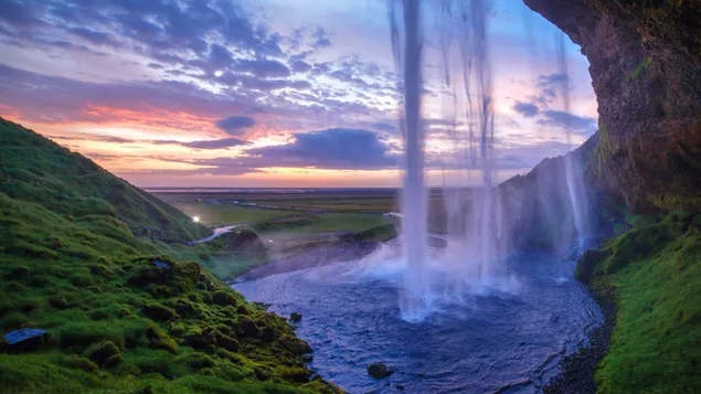 Vegetation und bewölkter Himmel neben Wasserfall und Wasser, das von hohen Felsen in den See fließt 8K Hintergrundbild