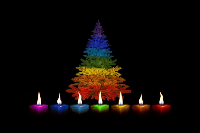 Velas de colores encendidas y pino de navidad decorado con colores