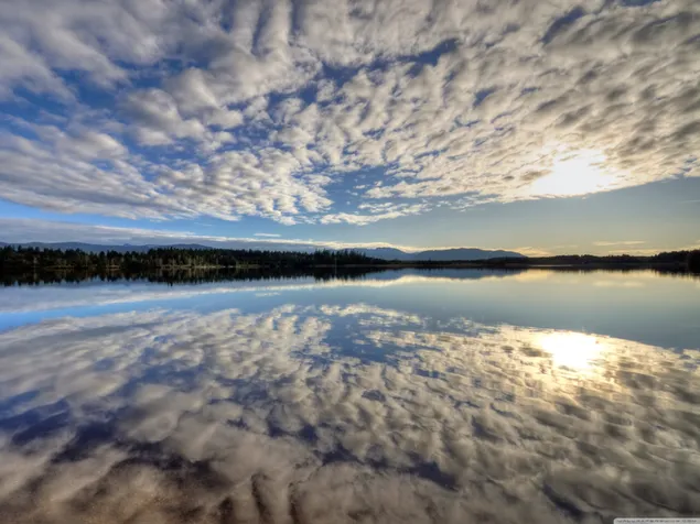 Vista del sol y las nubes reflejadas en el lago. 2K fondo de pantalla