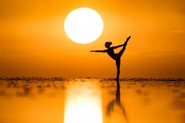 Vrouw sporten met uitzicht op de zon en weerspiegeling van de zon in het water