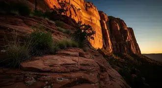 warm sunlight bathes rugged canyon walls and rocky terrain, highlighting the dramatic textures and colors of a breathtaking desert landscape at sunset download