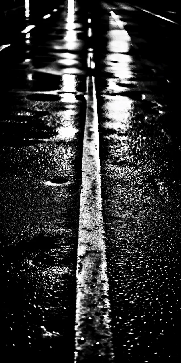 Nat asfaltpad met 'n wit lyn wat straatligte in die nag weerkaats 2K muurpapier