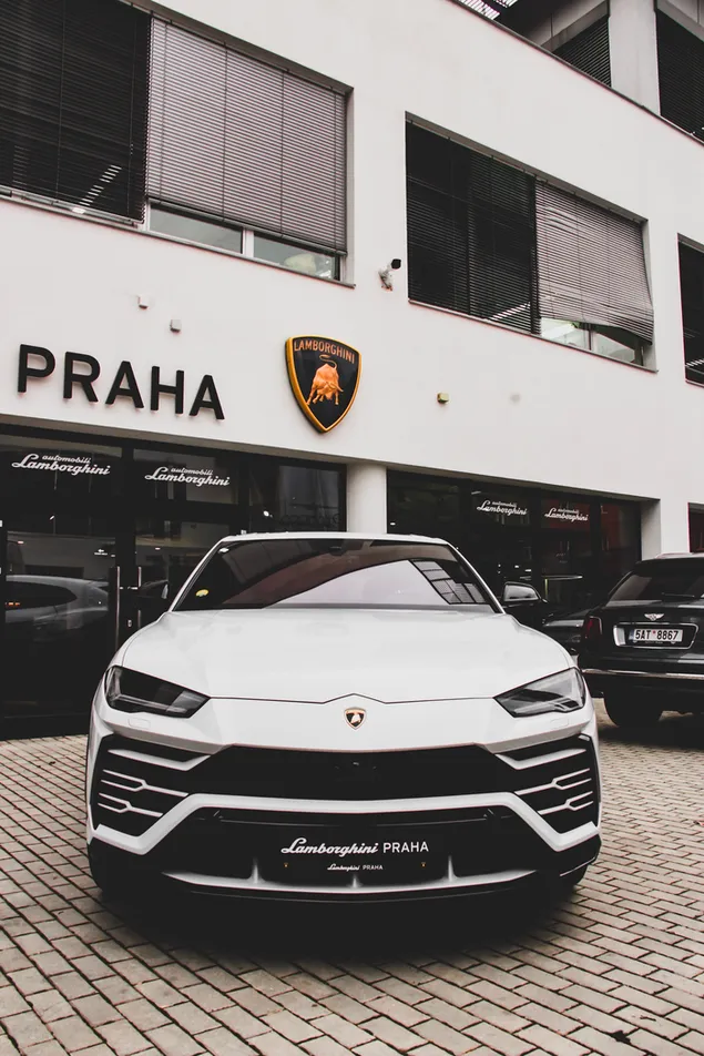 Weißer Lamborghini Praha parkte außerhalb des Ladens 2K Hintergrundbild