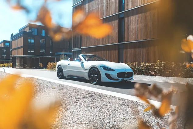 รถเปิดประทุน Maserati GT สีขาว จอดใกล้กำแพงสีน้ำตาล 4K วอลเปเปอร์