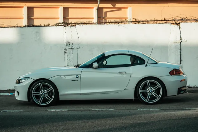 Witte BMW Z4 geparkeerd naast witte betonnen muur