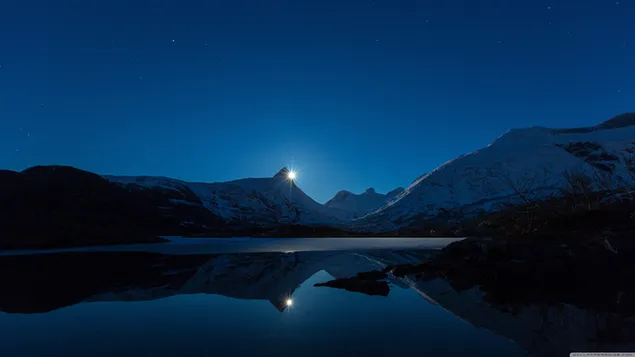 Wunderbare Aufnahme der nächtlichen reflektierten Landschaft mit schneebedeckten Bergen und Vollmond am See 4K Hintergrundbild
