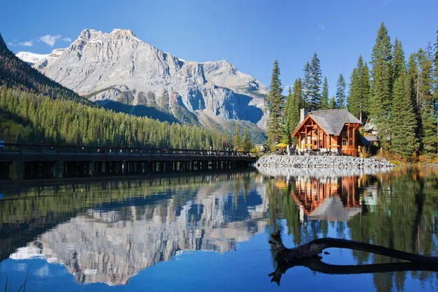 Holzhaus und kanadische Rockies rund um den See HD Hintergrundbild