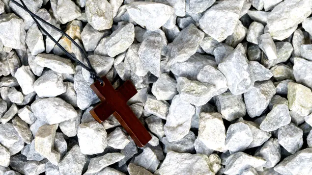 小石の上の木製の十字架のネックレス