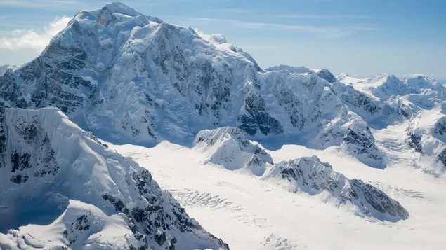 雪をかぶった岩と雪に覆われた山々のあるアラスカ