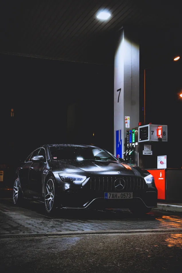 夜のガソリンスタンドで黒いメルセデスベンツ車