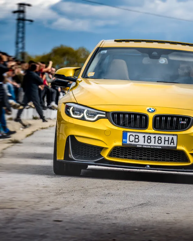Mobil BMW kuning di jalan unduhan