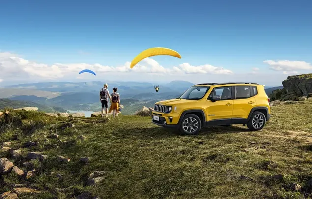 Yellow Jeep Compass van sportieve mensen die van paragliden houden 4K achtergrond