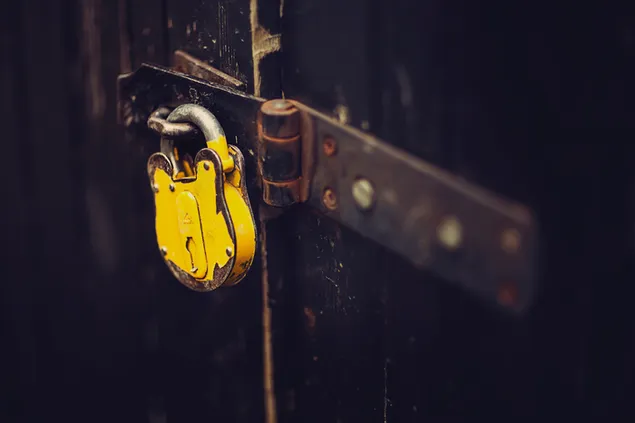 Candado amarillo colgado en la puerta de madera vintage descargar