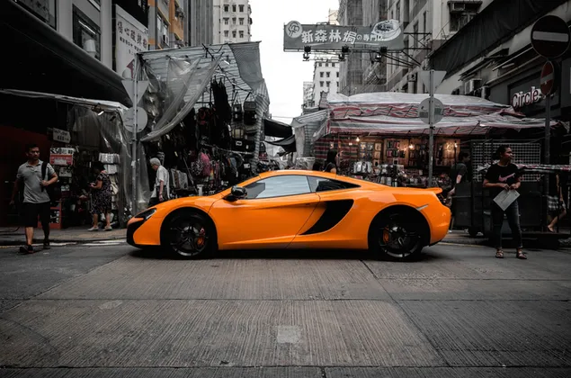 Gele McLaren-sportwagen op drukke markt