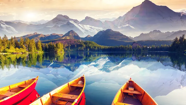 Cahaya matahari berwarna kuning, puncak bersalju, gunung, pohon, dan refleksi perahu kuning dan merah di air danau