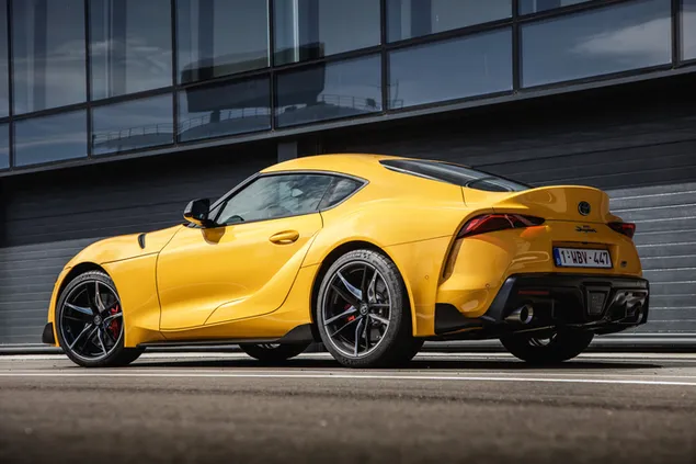 Geel Toyota Supra in die stad geparkeer aflaai